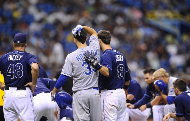 Ben Zobrist comforts Eric Hosmer of the Royals as the medical staff of the Rays and Royals attend to Alex Cobb on the field Saturday at Tropicana Field. (Photo courtesy of Brian Blanco/AP)