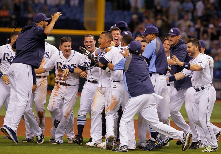 The Rays mob Yunel Escobar after his single over Tigers centerfielder Austin Jackson’s head drives in Sam Fuld with the winner in the 10th. (Photo courtesy of Daniel Wallace/Tampa Bay Times)