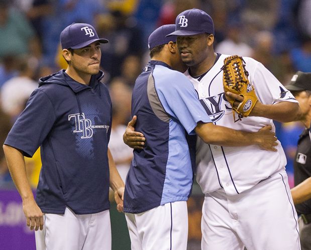 Roberto Hernandez, right, gets a hug from rookie Chris Archer after pitching his first complete game since September 2010. (James BOorchuck/Tampa Bay Times)