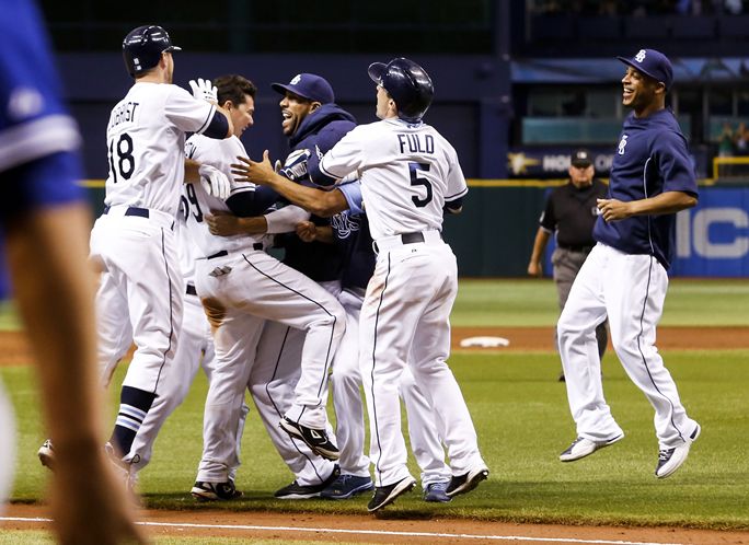Rays players converge on catcher Jose Lobaton, second from left, after his ninth-inning triple delivers another walkoff victory. (Photo courtesy of Will Vragovic/Times)