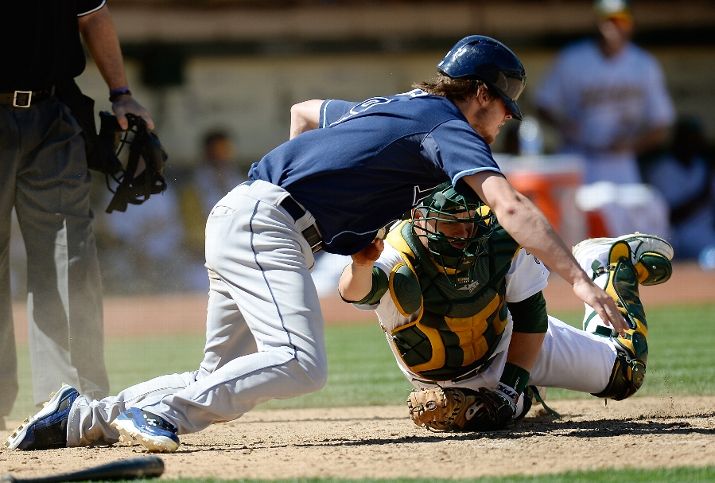 Wil Myers dives back to touch home plate and gets tagged out by Stephen Vogt in the seventh inning on September 1, 2013. (Photo by Thearon W. Henderson/Getty Images)